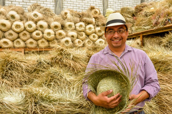Moisés Genaro Sánchez, owner of Sombreros Sanchez, with locally produced straw hats distributed by his business. Moisés's father started the company with loans from Concreces in 1993. By 1995 the company was selling in Mexico and the USA.