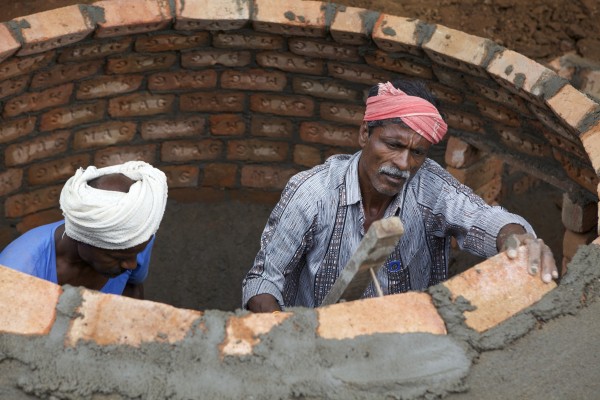 Men building underground unit where organic waste becomes biogas