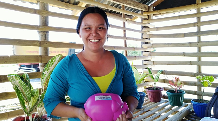 Irene Valdez with her piggy bank in which she put savings from her small retail store towards her planned pig-raising project
